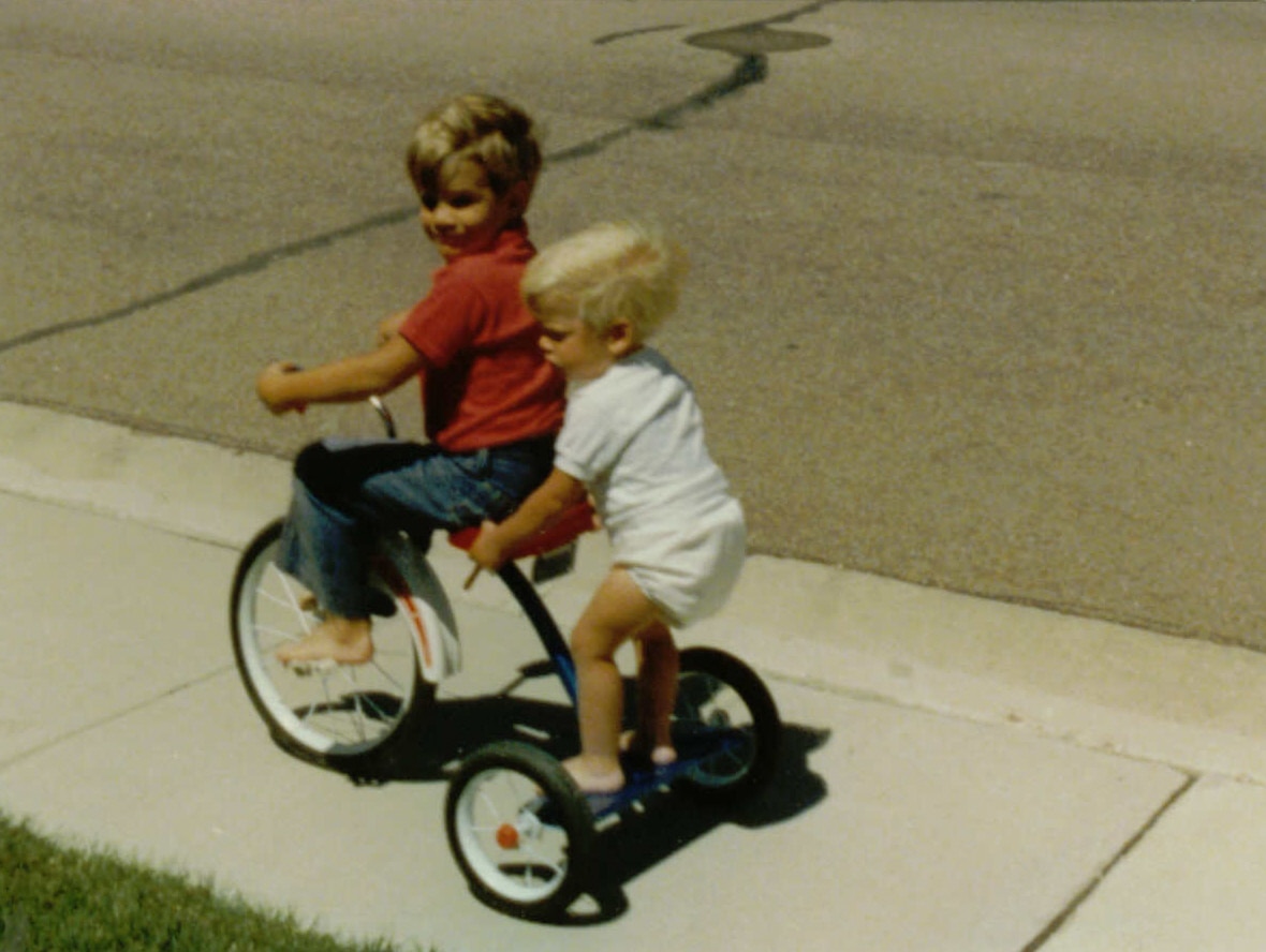 Brad Lovell and his brother playing on a tricycle when they were kids.
